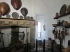 IMG_3399  Bunratty Castle.  Kitchen with turtle shell cooking pans above the fireplace.JPG